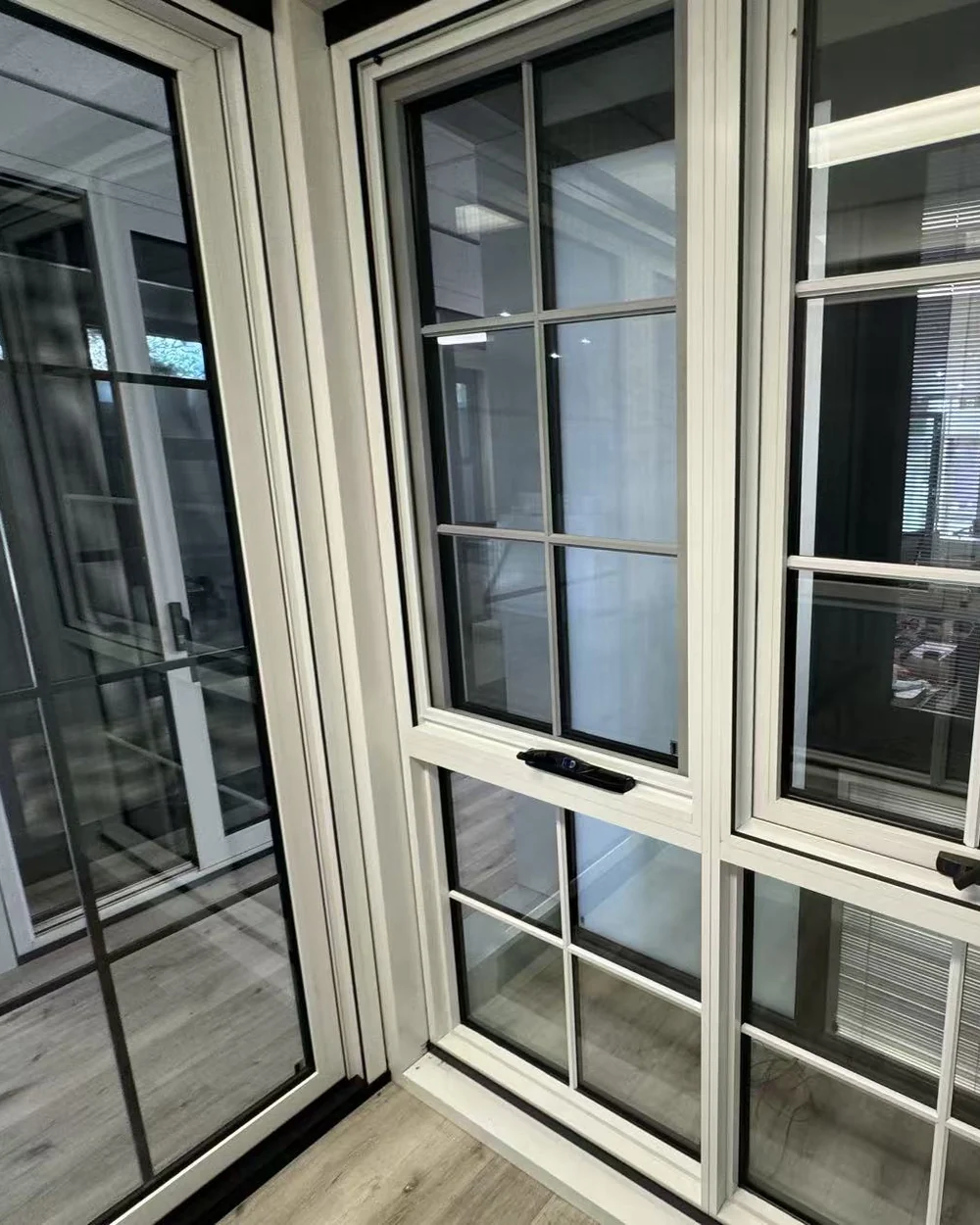 White aluminium awning windows with opening hardware at the Iconic Windows showroom