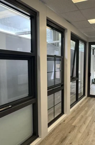 Custom black aluminium awning and fixed window configurations at the Iconic Windows showroom
